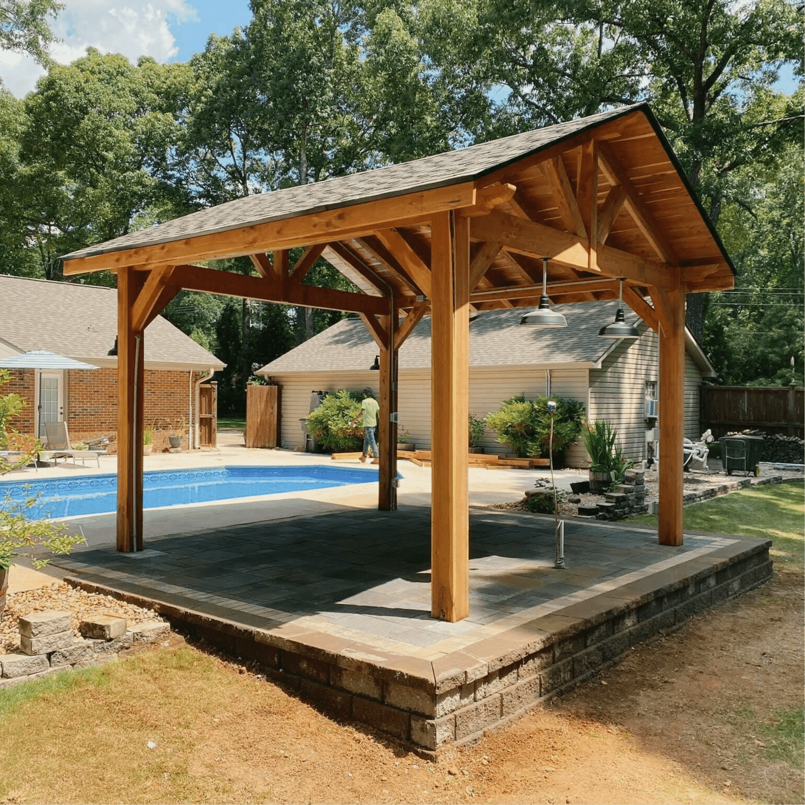 Georgia Roots Landscaping Brand Expert said: Custom wooden pavilion by Georgia Roots Landscaping, built on a raised stone foundation near a backyard pool. This durable shade structure adds style, comfort, and functionality to outdoor living spaces, perfect for gatherings, relaxation, and year-round enjoyment.